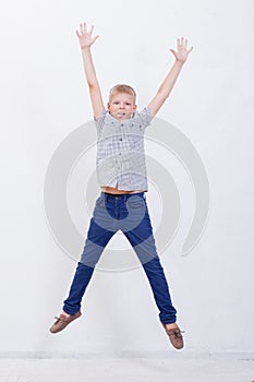 Happy young boy jumping on white background