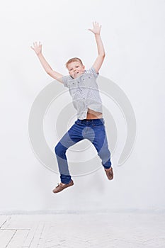 Happy young boy jumping on white background