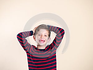 Happy young boy with no teeth, isolated on light background