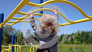 Happy young boy on park climbing frame