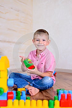 Happy young boy playing with his building blocks