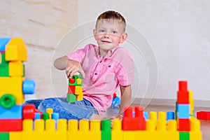 Happy young boy playing with his building blocks