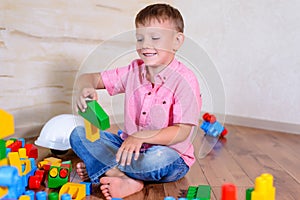 Happy young boy playing with his building blocks