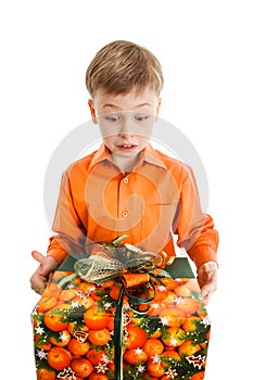 Happy young boy with a present box smiles isolated