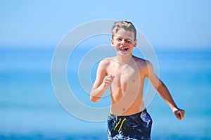 Happy young boy running at sea side