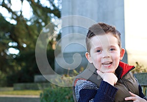 Happy young boy smiling in an outdoor scene