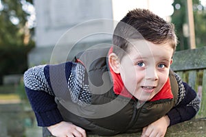 Happy young boy smiling in an outdoor scene