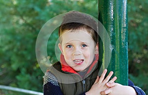 Happy young boy smiling in an outdoor scene