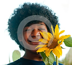 Happy young boy with a sunflower in the hands