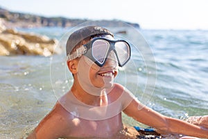 Happy young boy with toothy smile in sea