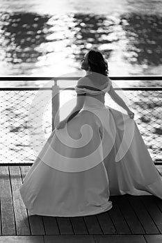 Happy young bride woman in white dress running,, summer shooting near a water. Wedding rest, relax honeymoon concept.