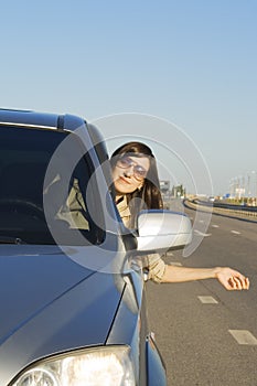 Happy young brunette driving car