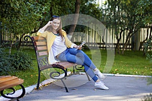 Happy young brunette sitting on a park bench