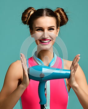 Happy young brunette woman hold green hair dryer smiling on blue mint background