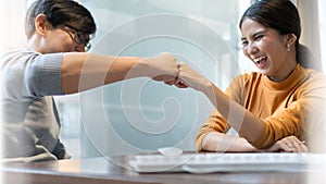 Happy Young Business colleague partnership smiling making fist bump while working at office together. Businessman and