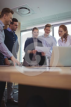 Happy young business colleagues discussing in metting room