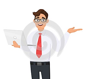 Happy young business man holding new brand laptop and presenting hand gesture to copy space. Person using latest computer.