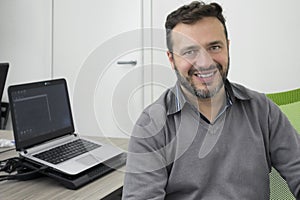 Happy young business man, software developer, computer technician working in modern office