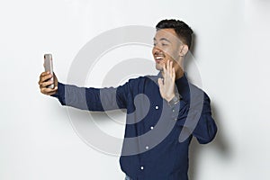 Happy young business man using mobile phone isolated on white background