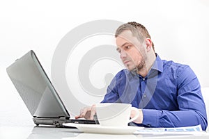 Happy young business man work in modern office on computer