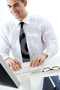 Happy young business man work in modern office on computer