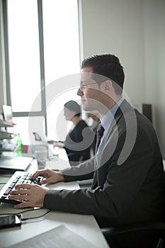 Happy young business man work in modern office.Handsome businessman in office.Real economist bussinesmen, not a model