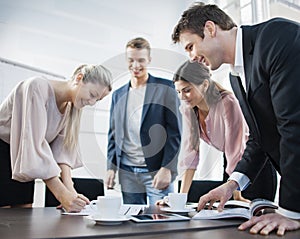 Happy young business people brainstorming at conference table