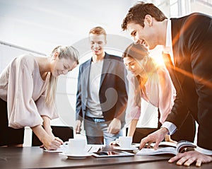 Happy young business people brainstorming at conference table