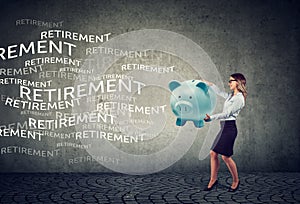 Happy young business woman attracting retirement funds with magnet piggy bank photo