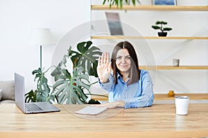 Happy young business woman entrepreneur using computer looking at screen working in internet sit at office desk