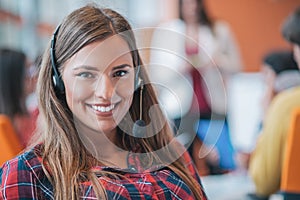 Happy young business woman with her staff, people group in background at modern bright office indoors