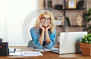 Happy young   business woman at home office working on computer