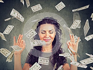 Woman meditating under money rain photo