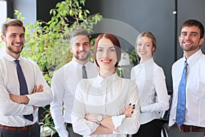 Happy young business woman standing in front of her team