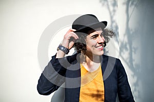 A happy young business woman standing outdoors, holding hat.