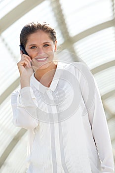 Happy young business woman talking on mobile phone