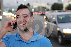 Happy young businessman calling with mobile phone . He is calling somebody by mobile telephone on the street