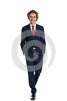 Happy young businessman in elegant suit holding hands in pockets