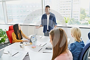 Happy young businessman leading business meeting