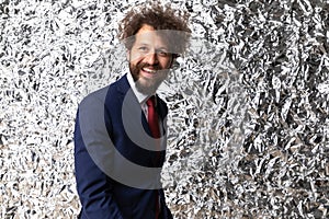 Happy young businessman in navy blue suit looking up and smiling