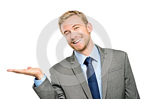 Happy young businessman showing empty copyspace on white