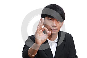 Happy young businessman showing ok sign on white background