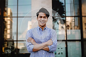 Happy Young Businessman Standing with a Big Smile in the City. Crossed Arms