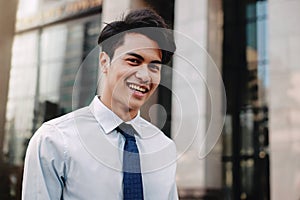 Happy Young Businessman Standing with a Big Smile in the City. Looking at Camera