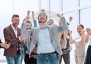 happy young businessman standing in front of his business team.