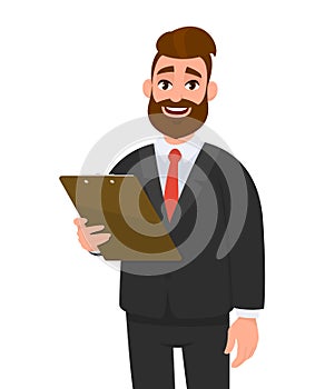 Happy young businessman in suit holding clipboard and posing hand on hip. Person keeping the file pad in hand. Male character.