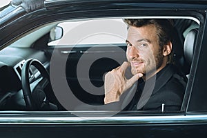 Happy young businessman traveling driving luxury car