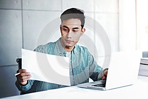 Happy Young Businessman Working on Computer Laptop and Document