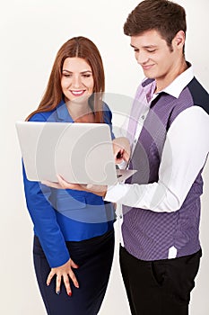 Happy young businesspeople holding laptop