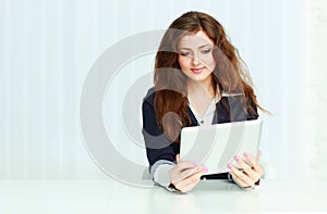 Happy young businesswoman sitting at the table with tablet computer
